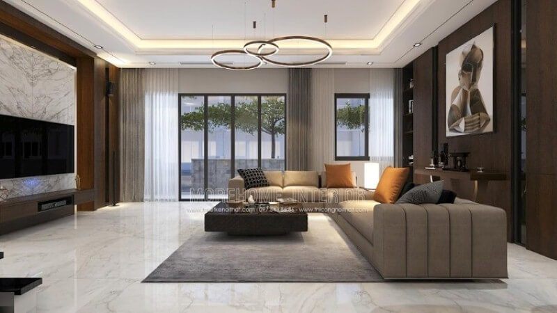 Mẫu bố trí nội thất phòng khách biệt thự hiện đại cao cấp lấy cảm hứng từ những tinh túy tuyệt đẹp từ tự nhiên, hệ thống cửa kính trắng lớn luôn mở để chào đón vượng khí từ tự nhiên, trang trí nhà sử dụng chất liệu gỗ kết hợp đá tự nhiên hòa quyện một cách khéo léo.